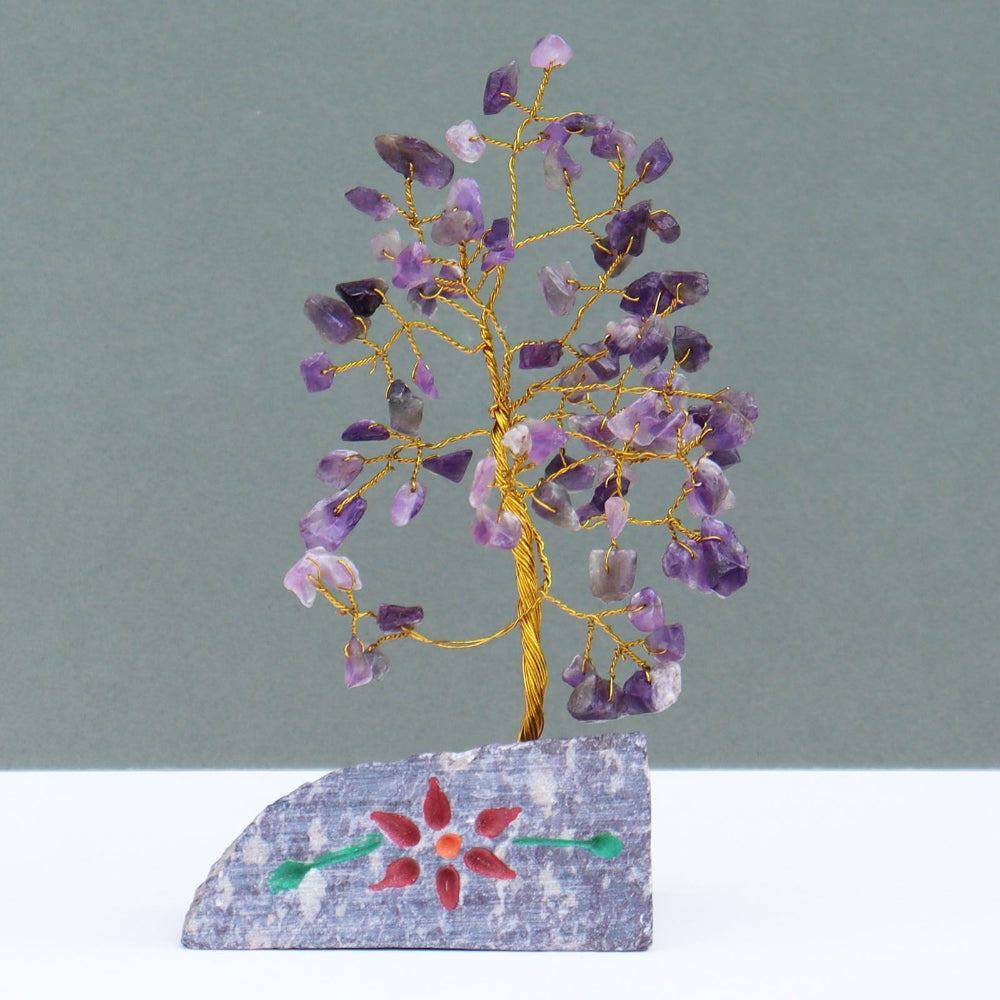 Decorative tree made of purple and pink stones on a gray background