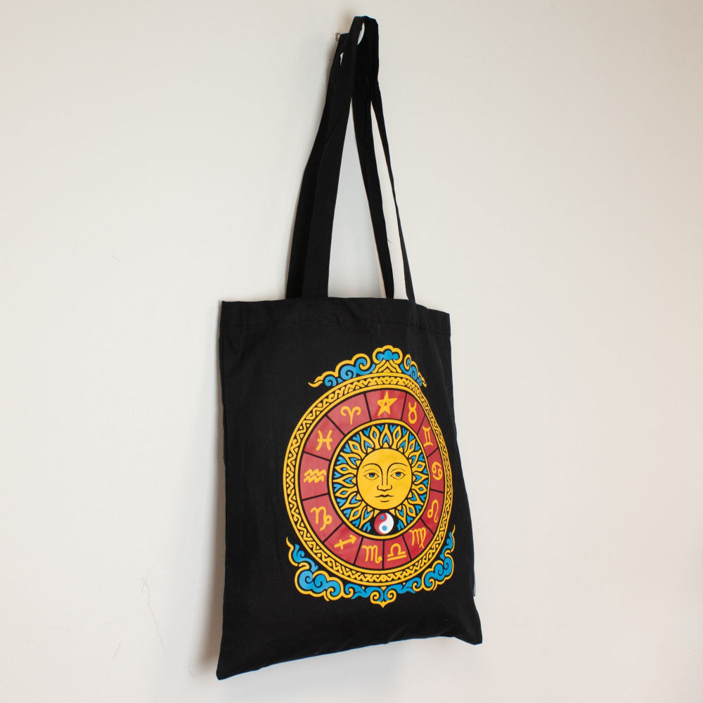 Black tote bag with colorful zodiac design on a white background