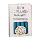 Winter Ritual Candles Blackberry & Pine scent in a light pink box with a clear window showing blue teal candles inside, and a circular star of David wreath illustration on the front.
