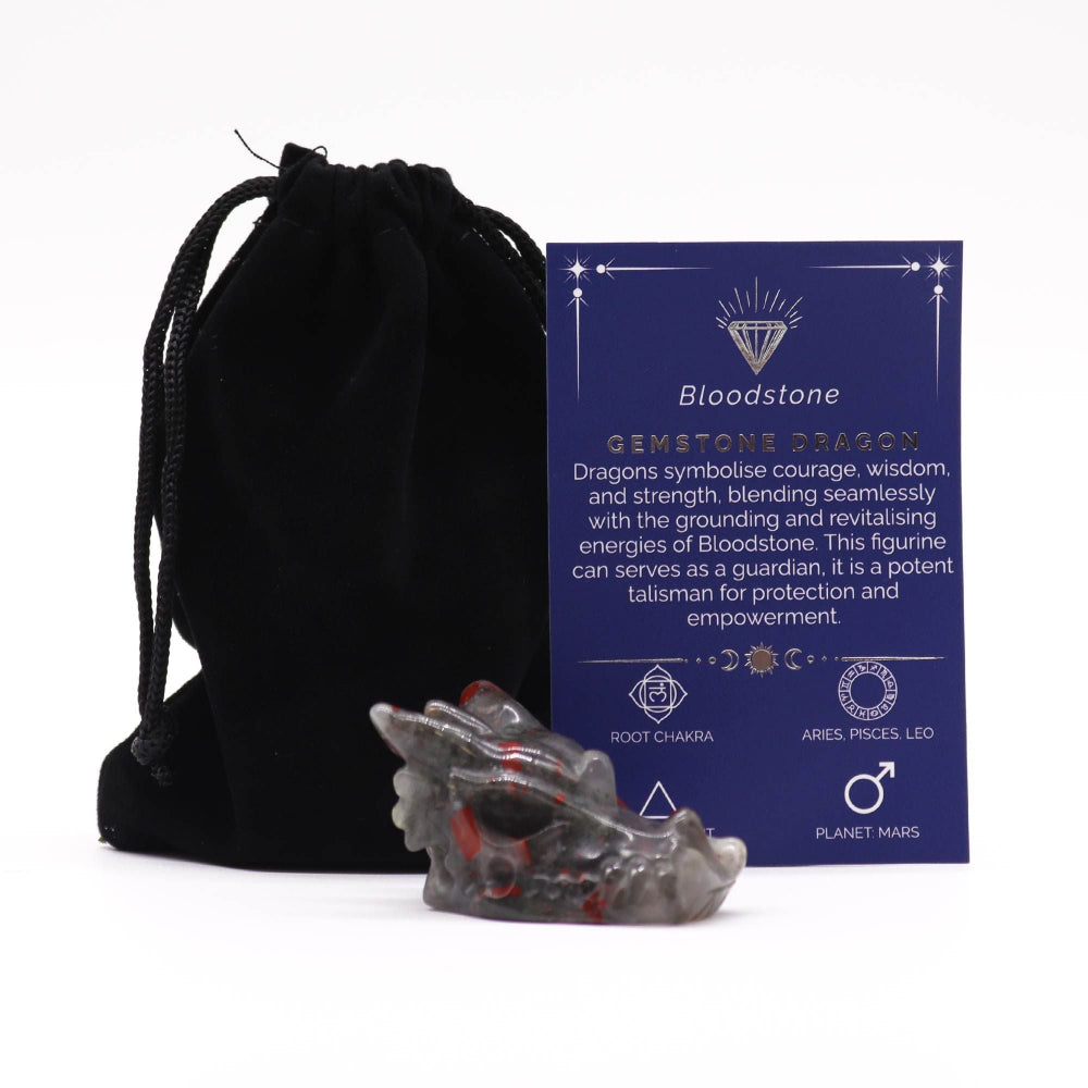 Crystal dragon figurine with a card explaining its properties, next to a black drawstring bag on a white background.