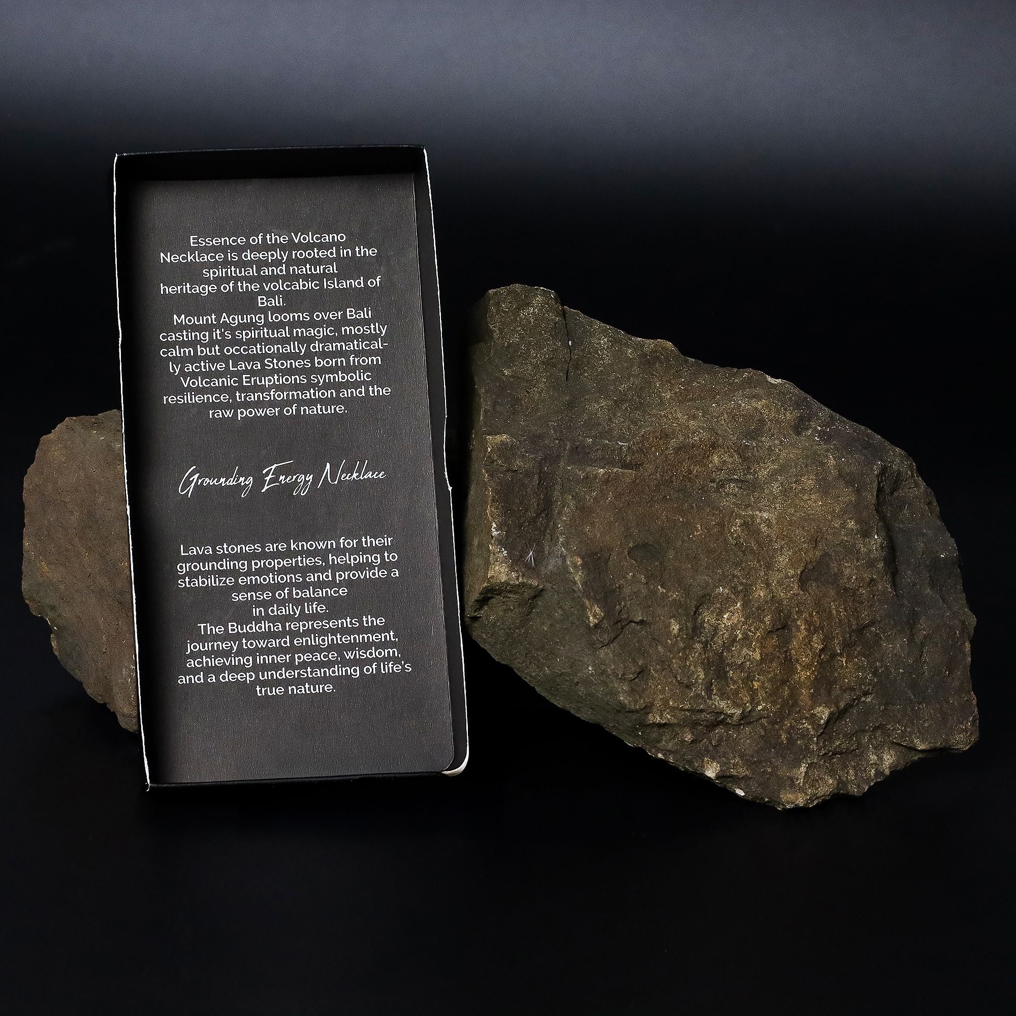 Rock with a black card displaying text next to it on a dark background