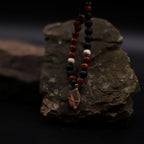Beaded necklace with a pendant on a dark rock