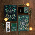 Collection of 'Green Witch' themed books, candles, and jewelry on a wooden surface.