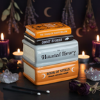 Book-shaped Oil burner with titles on a dark surface at Eleanora Moon