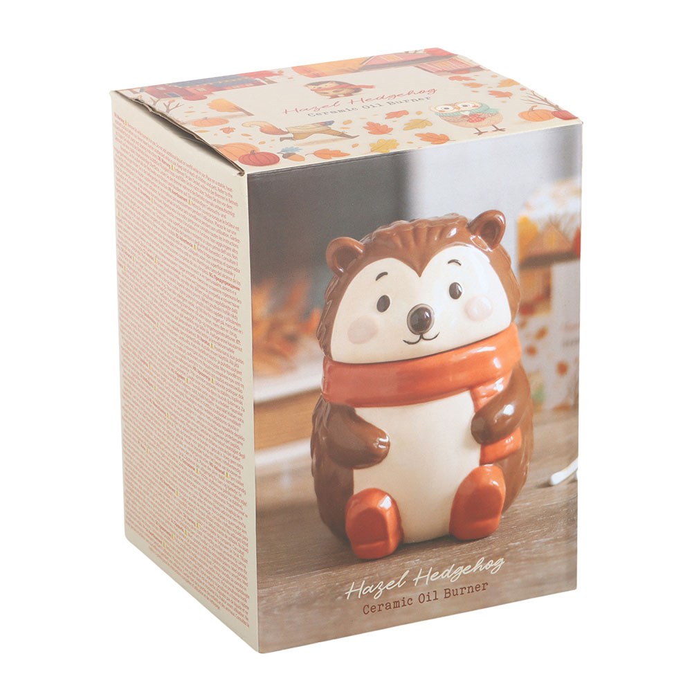 Ceramic oil burner shaped like a hedgehog in a box with a fall-themed design.