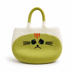 A cute, soft felt cat-shaped handbag in light green and white, featuring a sad face with red whiskers and black embroidered eyes and whiskers.