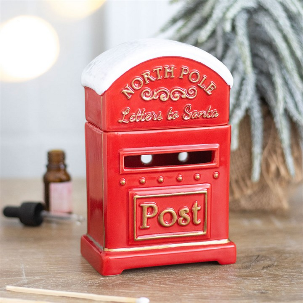 Red mailbox-shaped object with 'North Pole Letters to Santa' text on a wooden surface.