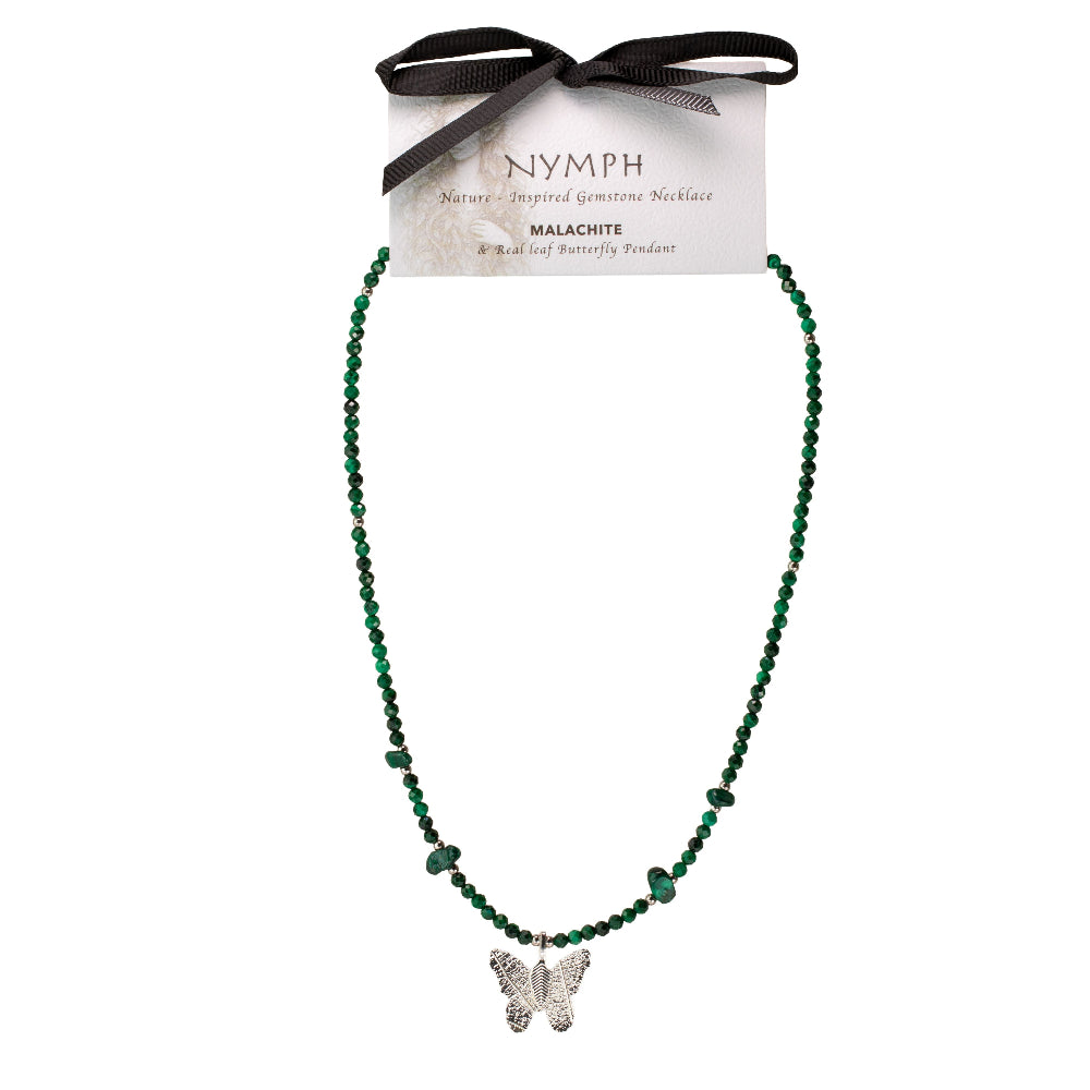 A beaded necklace with dark green malachite beads and a silver butterfly pendant, displayed on a branded card with a black ribbon bow. The card reads 'NYMPH Nature Inspired Gemstones Jewelry' and 'MALACHITE'.