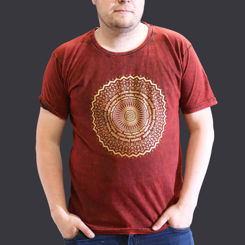 Person wearing a red t-shirt with a gold mandala design on a dark background