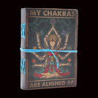 Journal with chakra design and text 'My chakras are aligned AF' on a white background