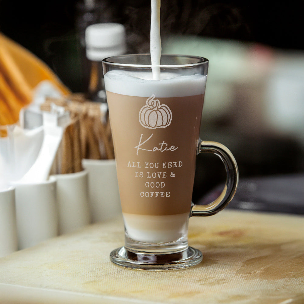 Glass mug with 'Katie' branding being filled with a layered coffee drink.