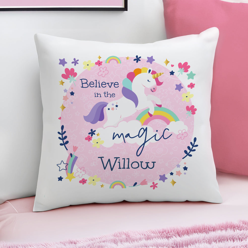 Decorative pillow with unicorn design and text 'Believe in the magic Willow' on a pink background.
