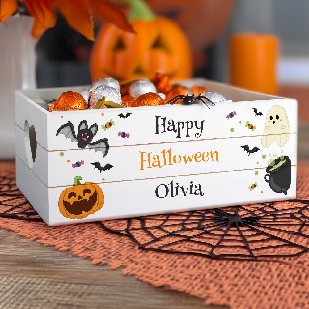 Halloween-themed candy box with decorative elements on a table with pumpkins and spider webs.