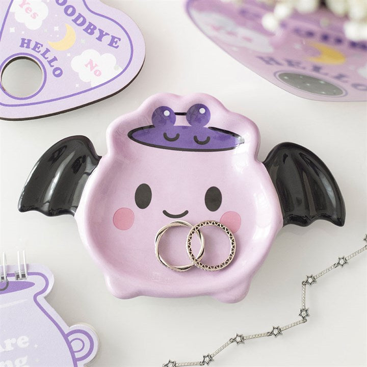 Pink bat-shaped ring holder with rings on a white background