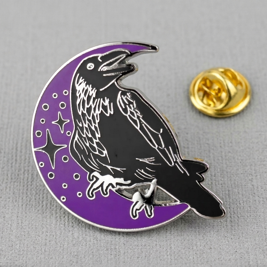 Pin with a black crow on a purple crescent moon design on a gray background