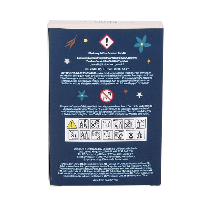 The back of a dark blue candle packaging box with white text, warning symbols, and small decorative star and flower illustrations, shown on a plain white background.