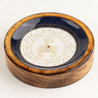 A circular wooden box with a polished wood-grain finish, featuring a dark blue glazed inner surface printed with a gold zodiac wheel centered around a scorpion motif.