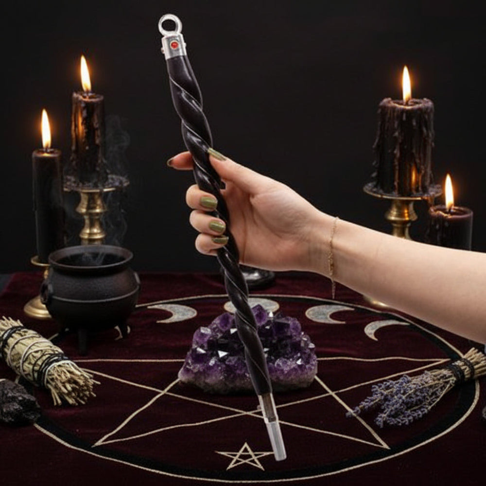 Hand holding a black and silver twisted wand against a white background