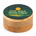 A round wooden keepsake box with a lid featuring a printed moon phase illustration and the text 'STAY WILD MOON CHILD' in cream lettering, shown on a plain white background.