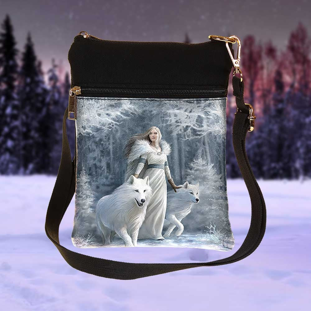 Crossbody bag with a winter scene print featuring a woman and white wolves.