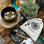 Tibetan singing bowl set with wooden stand, mallet, and pouch on a wooden surface.