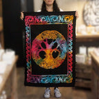 Person holding a colorful tapestry with a peace symbol and tree design.