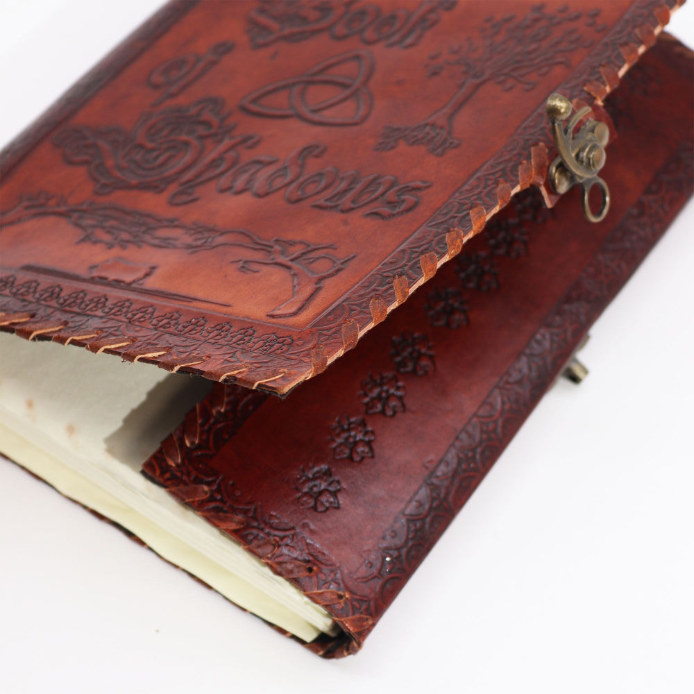 Brown leather notebook with embossed designs on a white background