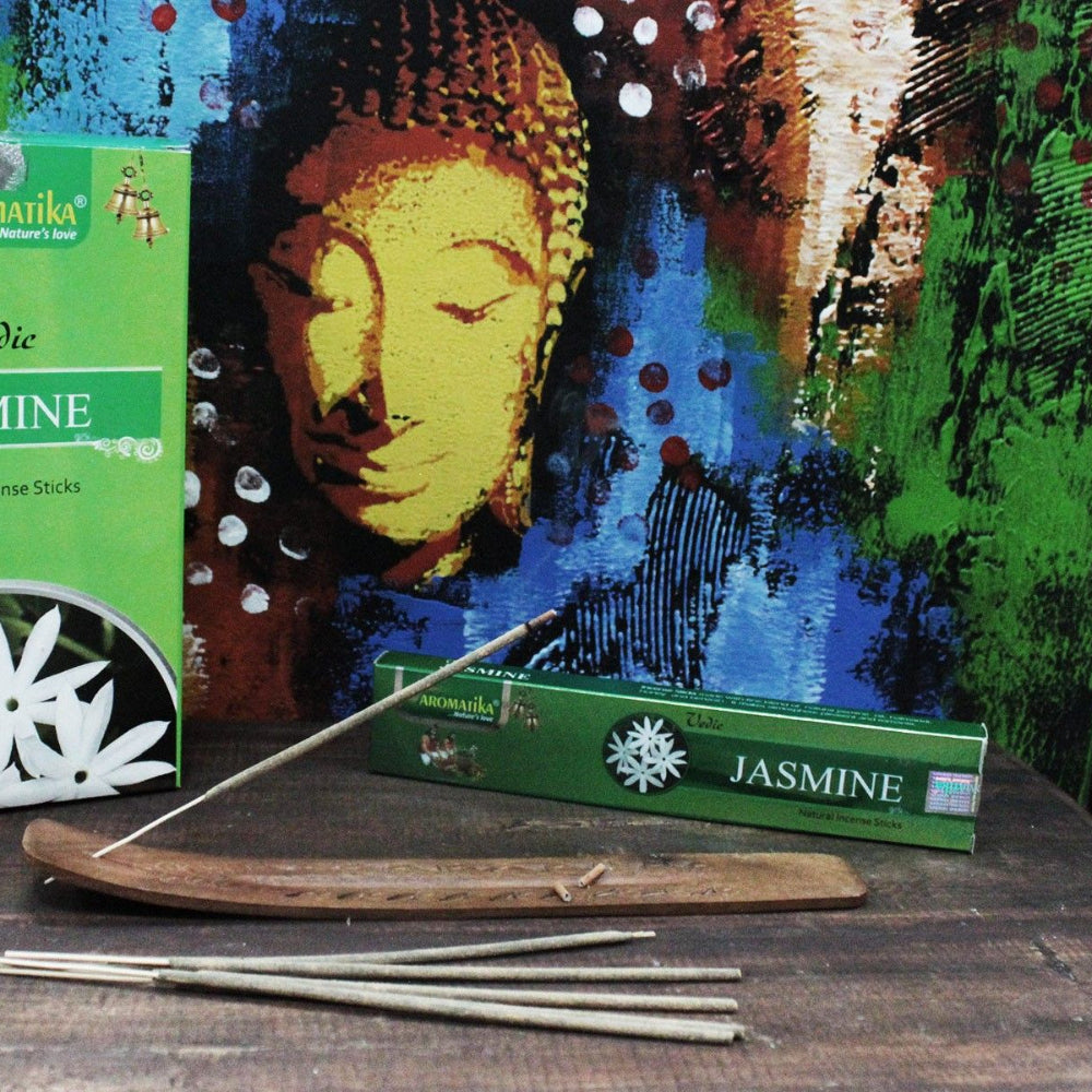 Aromatika Jasmine incense sticks with packaging and incense sticks on a wooden surface.