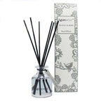 Reed diffuser with black sticks and a decorative box on a white background