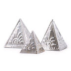 Three silver pyramidal objects with intricate designs on a white background