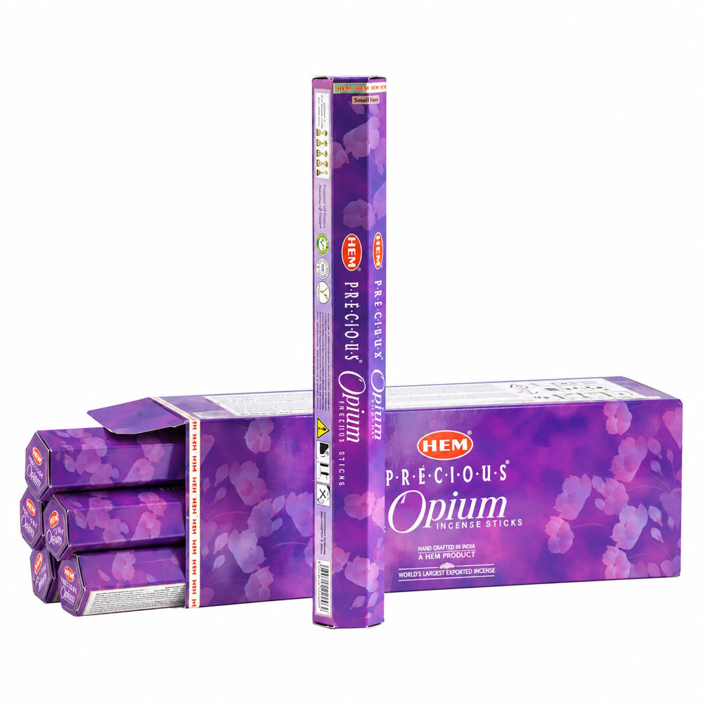 A pack of HEM Precious Opium Incense Sticks shown with a tall single stick standing upright in front of open boxes and loose sticks on a plain white background.