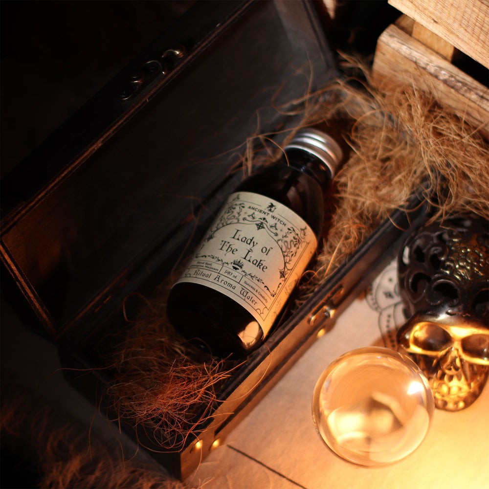Bottle labeled 'Lady of the Lake' in a decorative setting with candles and skull.