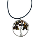 Tree-shaped pendant with stones on a black cord against a white background