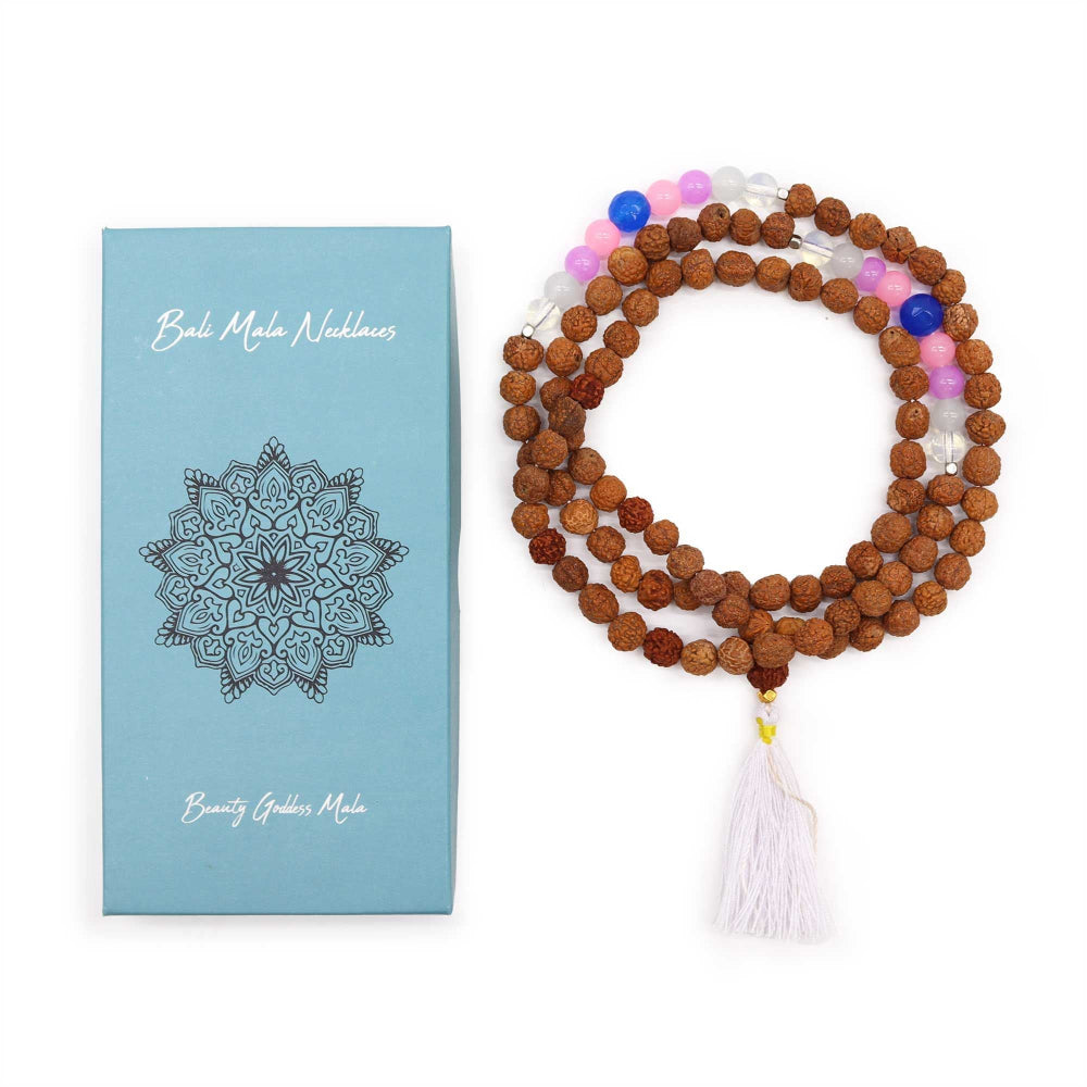 Bali Mala Necklace with colorful beads and tassel next to its packaging on a white background