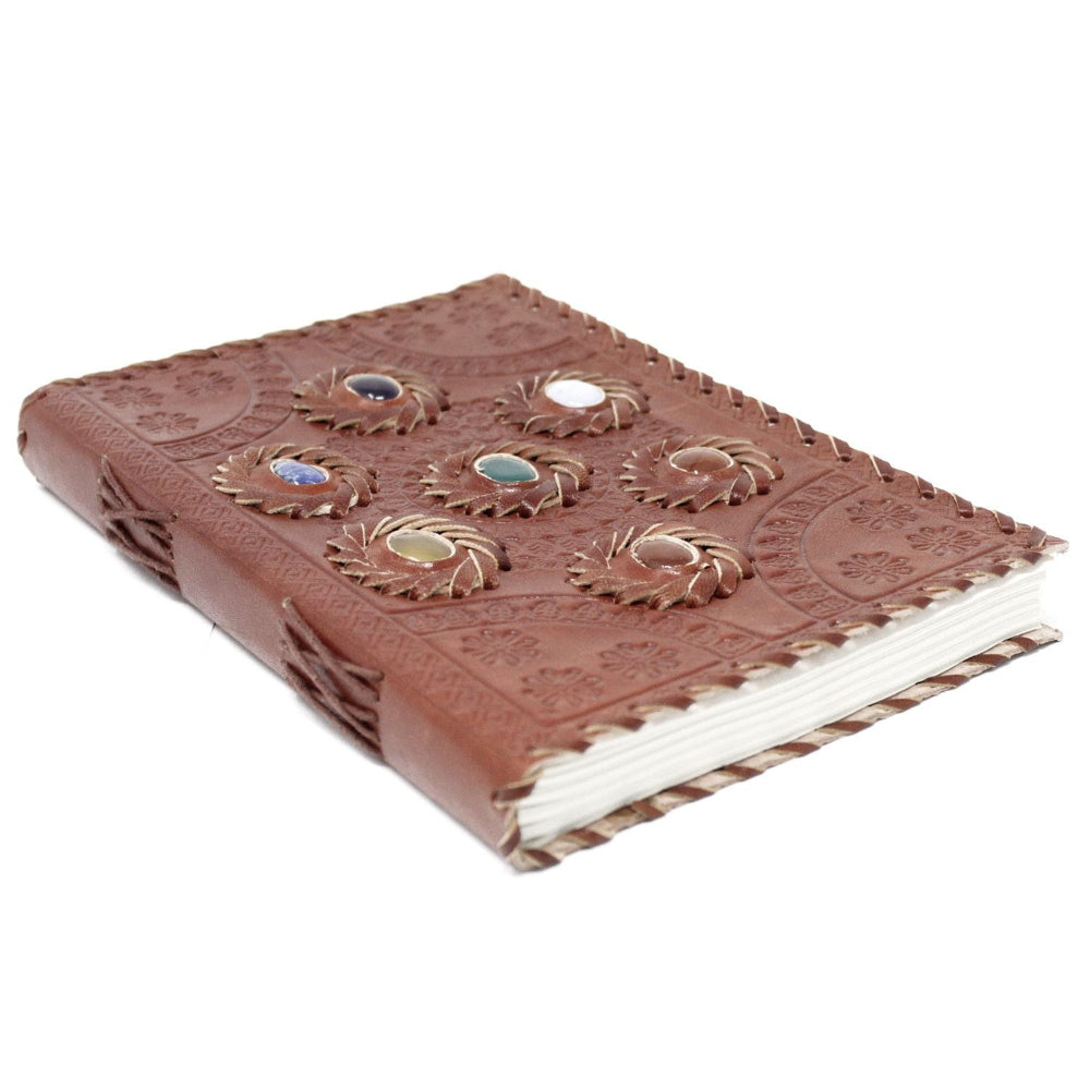 Brown leather notebook with embossed designs on a white background
