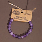 Purple beaded bracelet on a brown background with a label