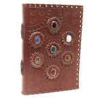Brown leather journal with embossed designs and decorative elements on a white background