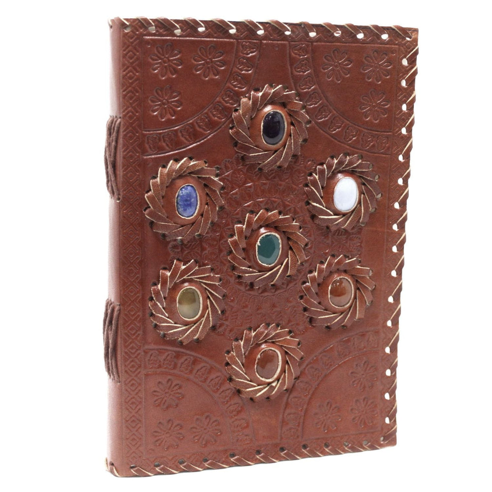 Brown leather journal with embossed designs and decorative elements on a white background