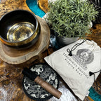 Tibetan singing bowl set with mallet and pouch on a wooden surface