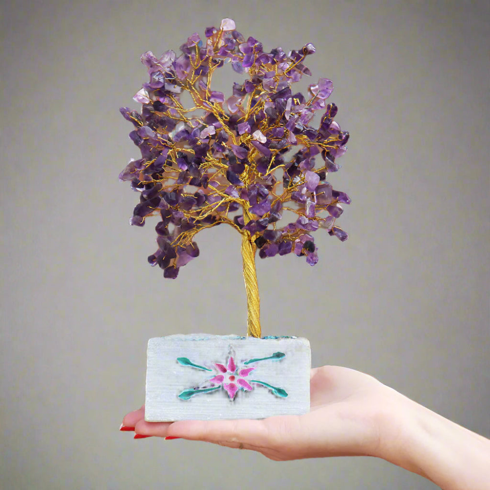 Hand holding a small tree with purple beads .Gemstone Tree at  Eleanoras