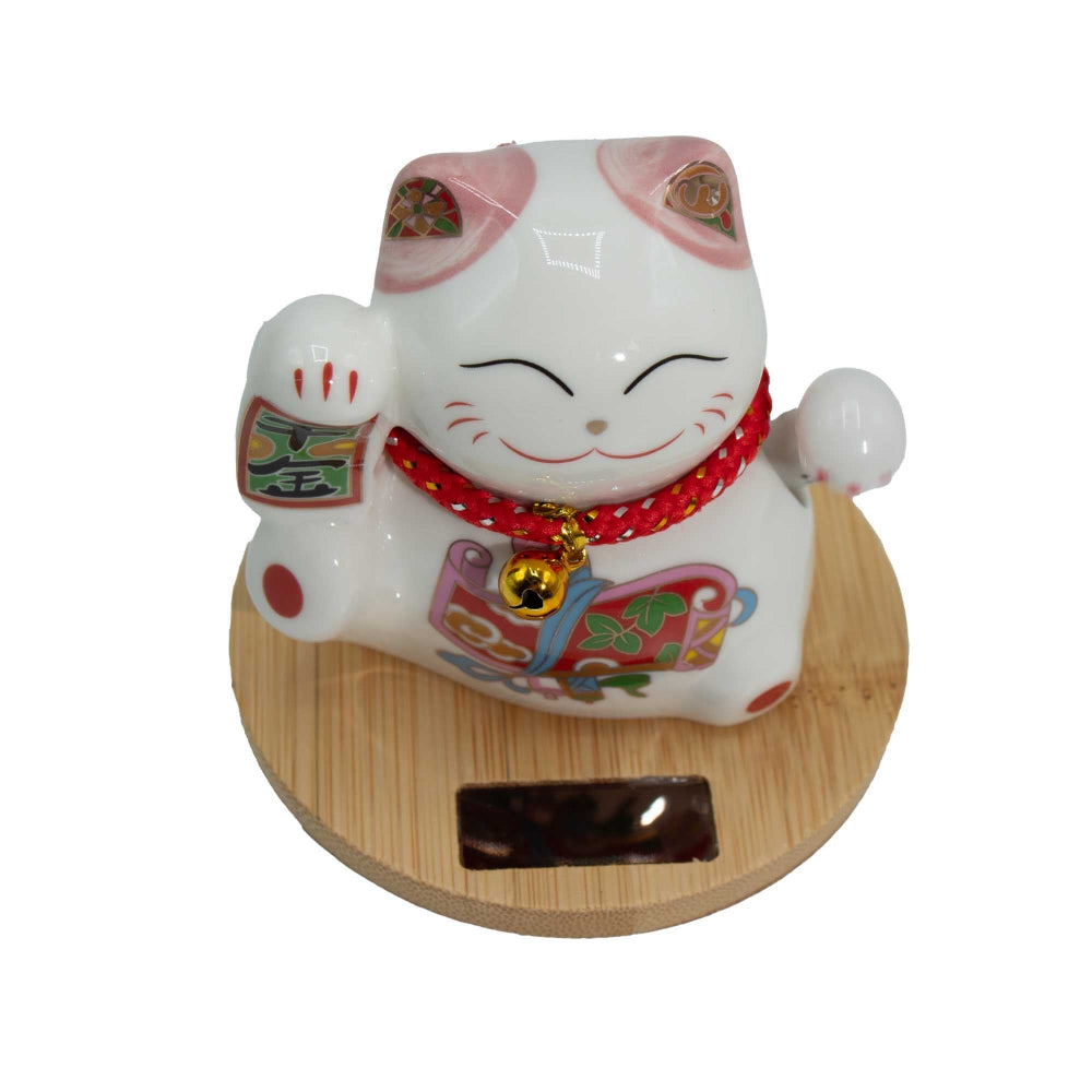 White cat-shaped figurine with red collar on a wooden base against a white background