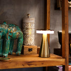 Gold lamp on a wooden shelf with decorative items in a rustic setting