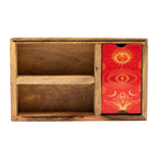 Wooden box with a red card featuring celestial designs on a white background