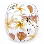 Clear glass with pressed flowers on a white background