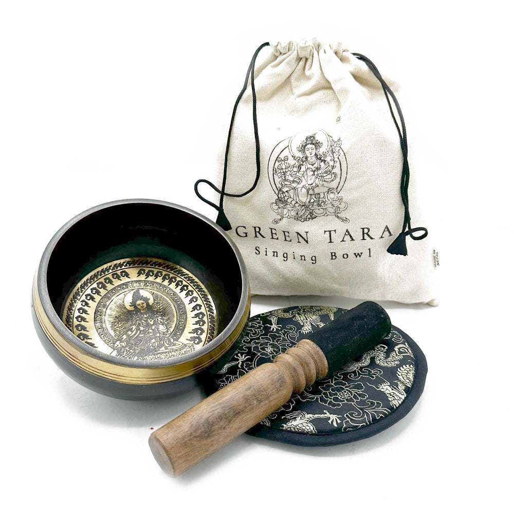 Singing bowl set with a drumstick and cloth pouch on a white background