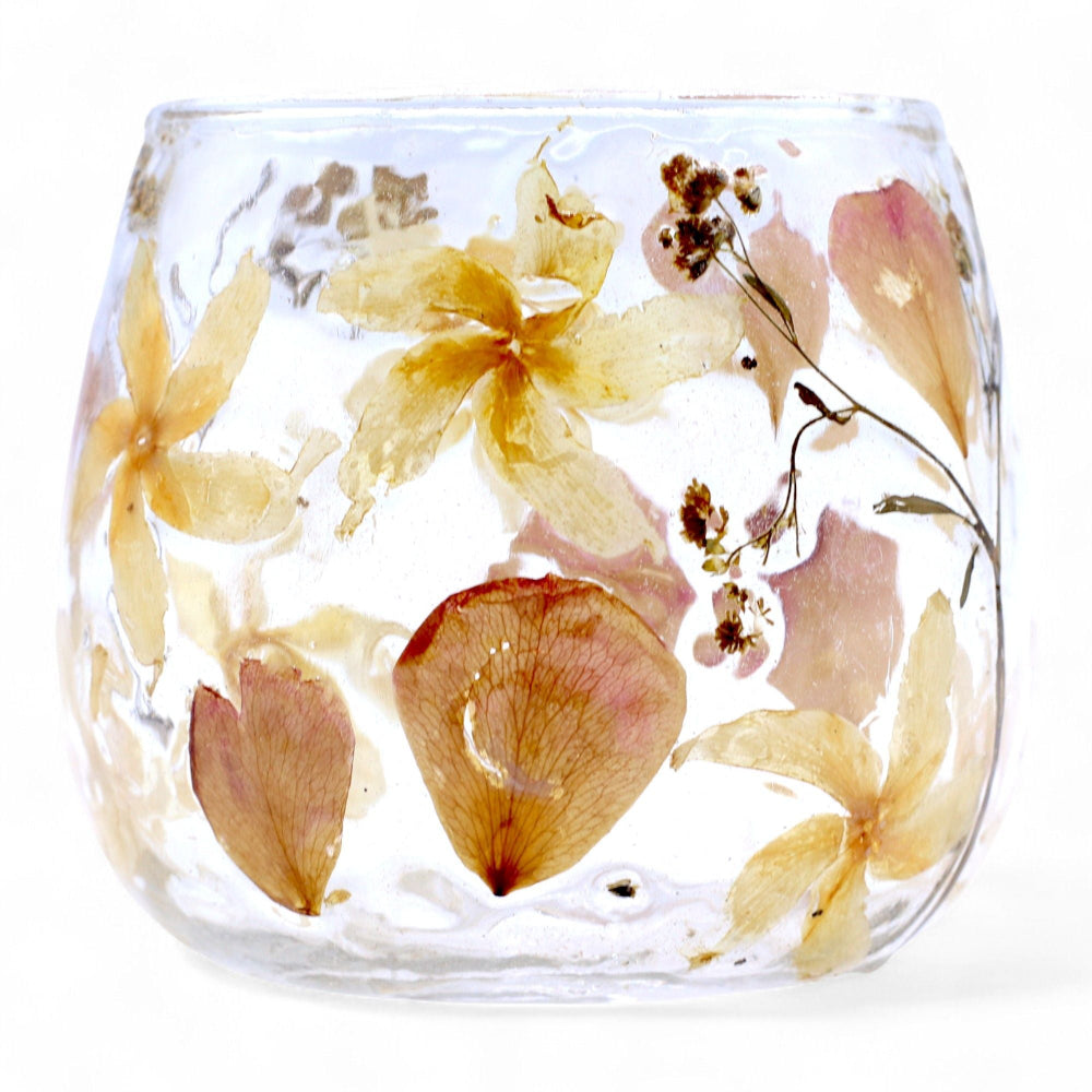 Clear glass vase with pressed flowers on a white background