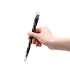 Hand holding a black and silver twisted pen against a white background