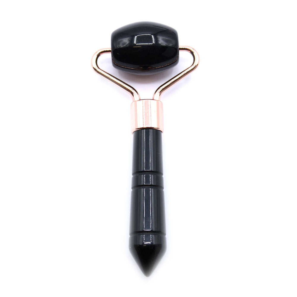 Black facial roller with gold accents on a white background