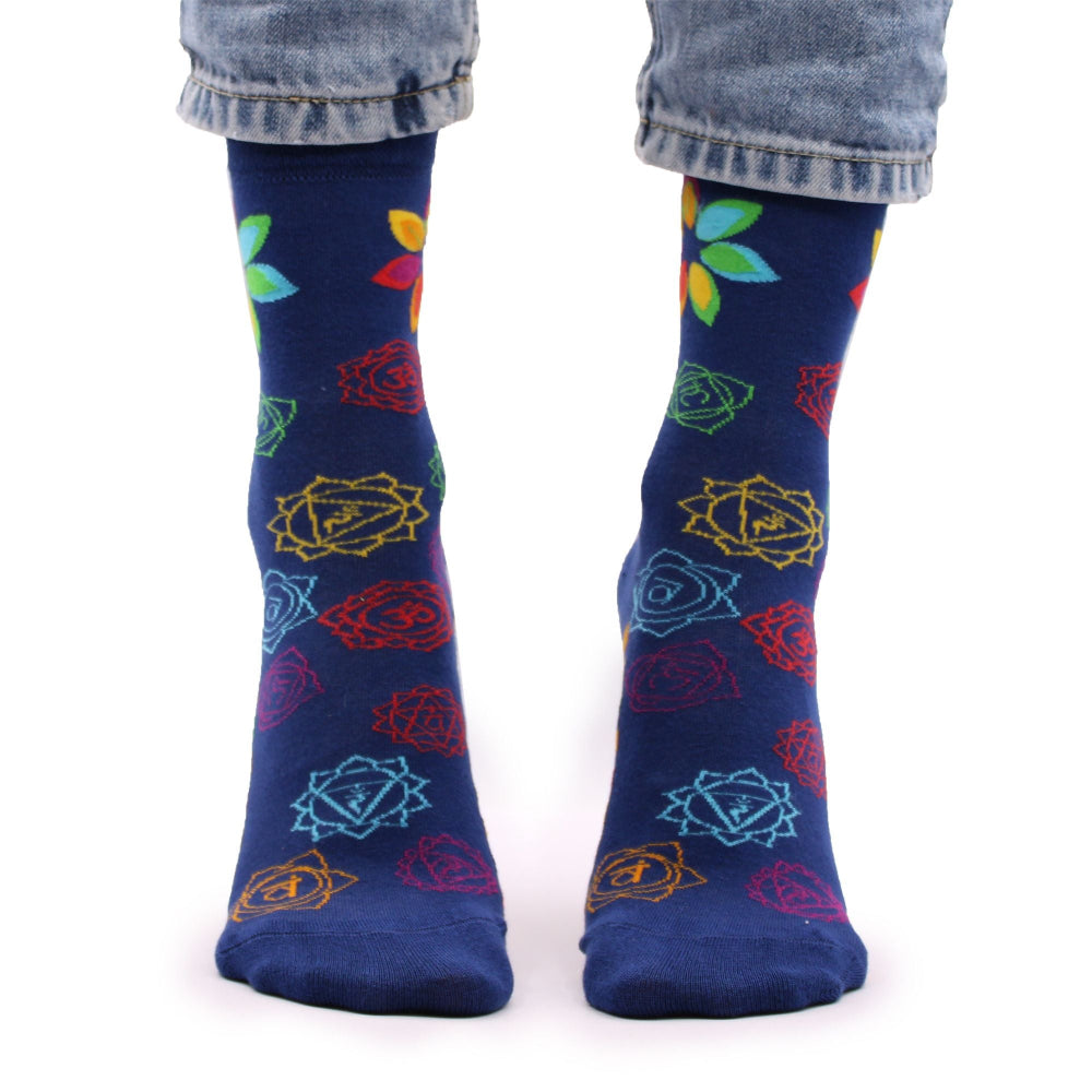 Blue socks with colorful patterns worn by a person on a white background