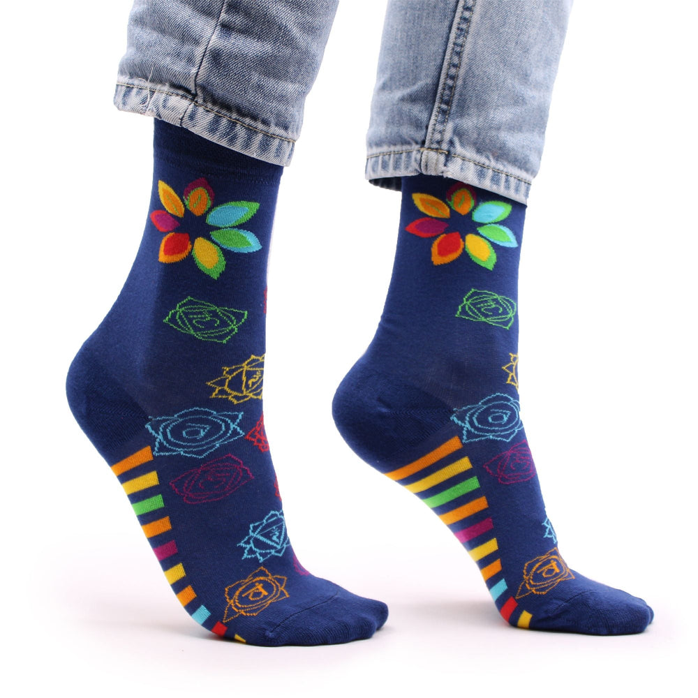 Navy blue socks with colorful floral and striped patterns worn with light blue jeans on a white background